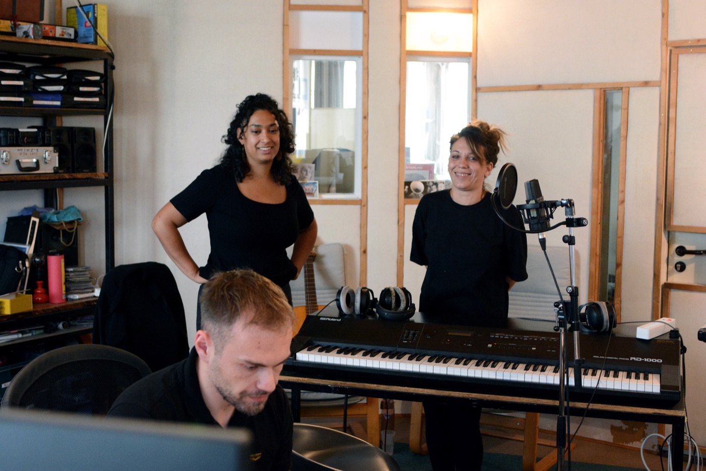 Collaborators beside the keyboard and vocal microphone during a session